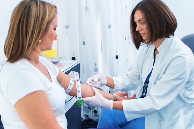 female health care worker drawing blood from a female patient.